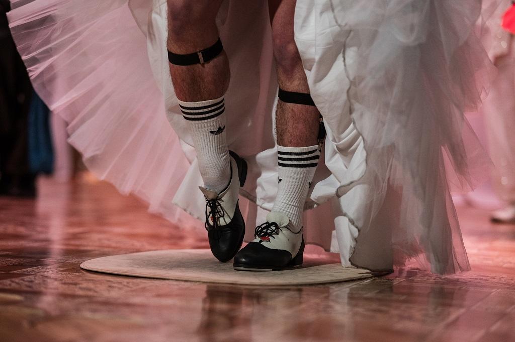 Zbliżenie na buty do stepowania, do których mężczyzna założył sportowe skarpetki i długą spódnicę.